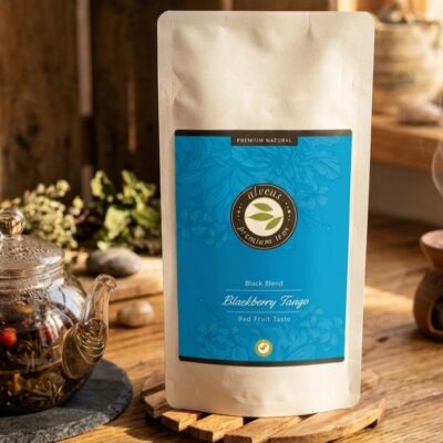 Un sachet de thé blackberry tango de la marque alveus posé sur une table en bois avec a coté une théière
